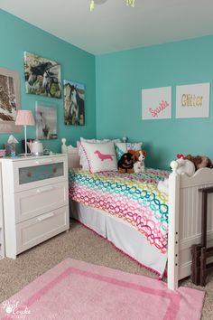 a child's bedroom with blue walls and pink carpeted rugs on the floor