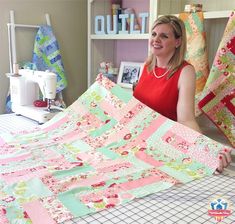 a woman sitting in front of a quilt