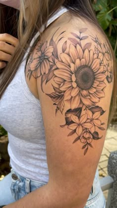 a woman with a sunflower tattoo on her shoulder