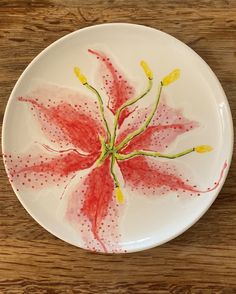 a white plate with a red flower painted on it