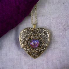 "Dragons breath bronze floral music box pendant. This heart shaped music box pendant is inspired by the gorgeous music box pendants of era's gone by. Music box is pill box size, please look at the dimensions for exact size.  A perfect bronze heart locket has been adorned with a layer of bronze filigree, a floral bezel with a round dragon's breath glass opal set in the center. The filigree and bronze bezel have been finished with resin to preserve the beauty of this pendant. The music box winds from a key on the back of the pendant. The pendant hangs from a 30\" bronze chain with a dragonfly toggle clasp. The locket opens and closes by pushing the little button on the side and reveals a tiny working music box that plays an 18 note musical tune.  Choose the music box tune you would like at c Antique Necklaces With Intricate Design For Keepsake, Antique Necklace With Intricate Design For Keepsake, Heirloom Filigree Locket Necklace For Gift, Antique Gold Jewelry With Heart Charm For Gift, Heirloom Filigree Locket Necklace Gift, Heirloom Locket Necklace With Intricate Design As Gift, Heirloom Locket Necklace With Intricate Design For Gift, Heirloom Necklace With Antique Finish As Gift, Antique Gold Heart Pendant Jewelry As Gift