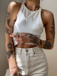 a woman with many tattoos on her arm and chest holding a cell phone in her hand