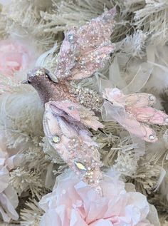 some pink flowers and white feathers on a table