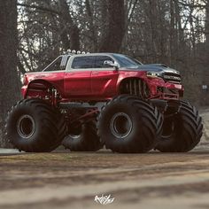 a red monster truck with big tires on the road