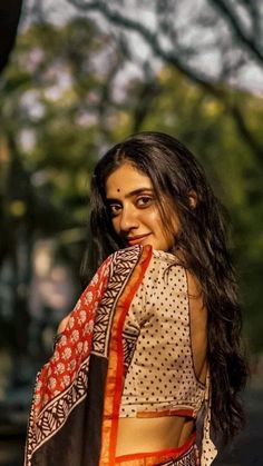 a woman with long hair wearing a sari