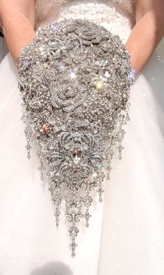 a close up of a person wearing a wedding dress made out of silver and white jewels