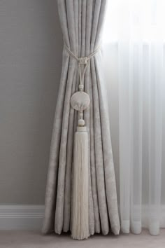 a curtain with a tassel hanging from it's side in front of a window