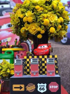 cars and flowers are on display in front of the race car themed centerpieces