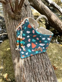 a blue bag hanging from the side of a tree