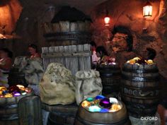 several wooden barrels with lights on them and people standing around in the background at disneyland's animal kingdom