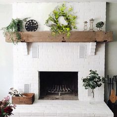 a living room with a white brick fireplace and potted plants on the mantel