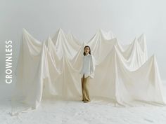 a woman standing in front of a white backdrop with the words crownless on it