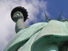 the statue of liberty is looking up into the sky