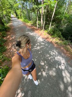 a woman is taking a selfie on a path in the woods with her cell phone