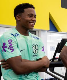 two young men standing next to each other in front of a gym equipment machine and smiling