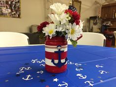 a red, white and blue mason jar with flowers in it sitting on a table