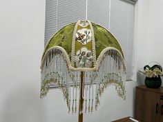 a lamp shade with beaded details on it in a room next to a window