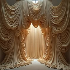 an open curtained room with light coming in from the window and drapes on the wall