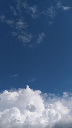 the airplane is flying high in the blue sky with white clouds behind it and on top of another plane