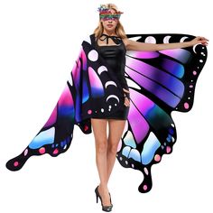 a woman in a butterfly costume is holding up a large colorful butterfly wings with eyes