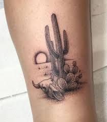 a small cactus and hand tattoo on the leg