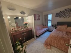 a bed room with a neatly made bed next to a mirror and a desk in front of it