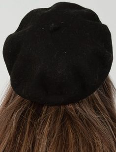 the back of a woman's head wearing a black hat