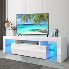 a flat screen tv sitting on top of a white entertainment center in a living room