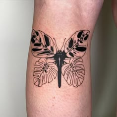 a black and white butterfly tattoo on the leg