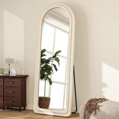 a large white mirror sitting on top of a wooden floor