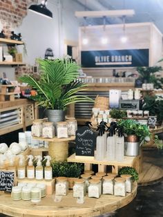 a table with plants and candles on it in a store display area that is filled with lots of items