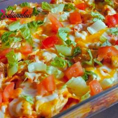 a casserole dish with tomatoes, cheese and lettuce