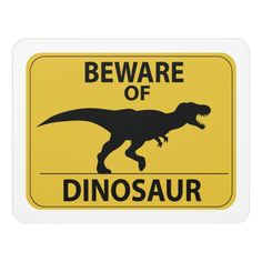 a sign that says beware of the dinosaur on it's back and yellow background