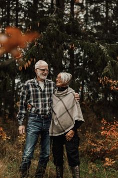 an older couple standing together in the woods