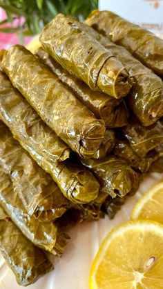 there are grape leaves and lemons on the plate