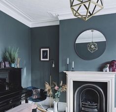 a living room filled with furniture and a fire place in front of a mirror on the wall