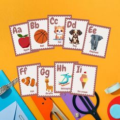 a table topped with lots of different types of cards next to scissors and paper clips