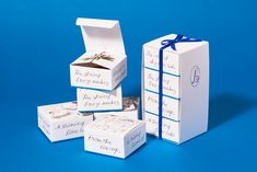 several boxes with writing on them sitting next to each other and tied with a blue ribbon