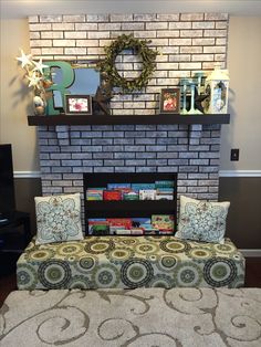 a living room with a fire place, couch and rug on the floor in front of it