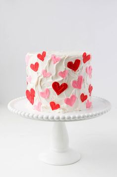 a white cake with pink and red hearts on it