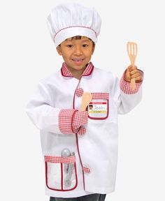 a young boy dressed in a chef outfit holding a spatula and pointing to the side