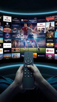 a person holding a remote control in front of a tv screen with many movies on it