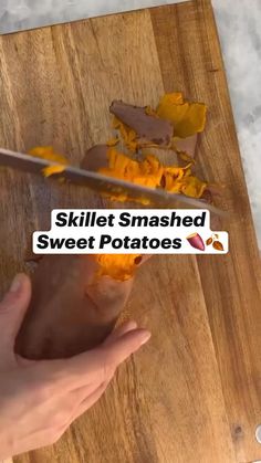 a person cutting up some food on top of a wooden table with the words skillet smashed sweet potatoes