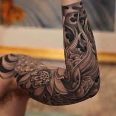 a man's arm with an intricate tattoo design on it