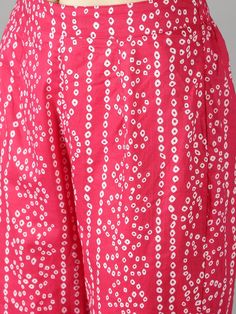 Fuschia Pink Bhandej Print Shirt with Black Bhandej Side Tie Up Paired with Statement Bottoms Fuschia pink cotton bhandej shirt kurta with pant set. Super trendy yet comfy. Black bhandej waist tie up give it a show-stopper look . Elastic waistband with lace detailing on the pant hem. Product doesn't have liningCold wash and Dry clean onlyLining Material: No lining Pattern: Bhandej Print Fit: Relaxed Model Height: The model (height 5'9", Chest 34", Waist 28", Hip 38") is wearing Size Small Measur Pink Pant Set With Straight Kurta, Traditional Pink Pant Set For Spring, Pink Bollywood Pant Set With Chikankari Embroidery, Pink Cotton Sets With Printed Motifs, Pink Cotton Salwar Kameez With Block Print, Pink Block Print Sets For Spring, Spring Pink Block Print Sets, Spring Block Print Pink Sets, Pink Cotton Salwar Kameez With Printed Motifs