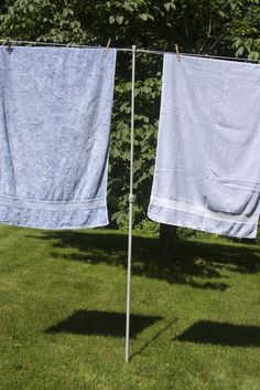 two blue towels hanging on clothes line in yard