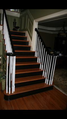 the stairs are painted black and white with wood treads on each handrail, along with hardwood flooring