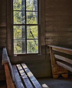 a wooden bench sitting in front of a window