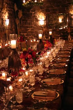 a long table is set up with candles and place settings for dinner guests to enjoy