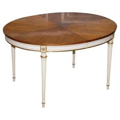 an oval wooden table with white trimmings and gold accents on the top, against a white background